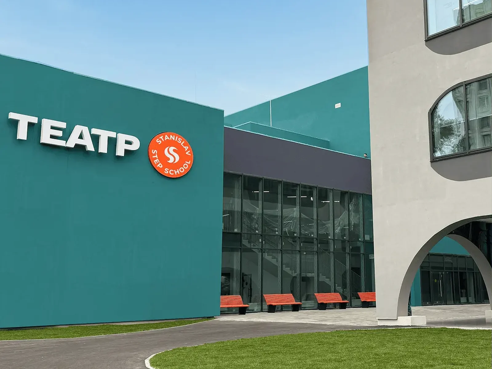 Вхід до шкільного театру: бірюзовий фасад із вивіскою «Театр» і лавками